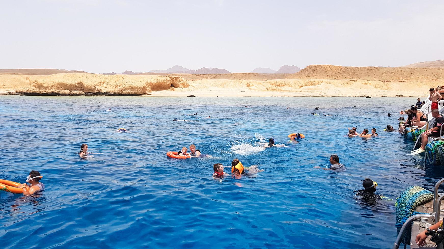 egypte, sharm el sheikh - 20 september 2019. een groep toeristen die met een masker en snorkel duiken, kijken naar de prachtige en kleurrijke zeevissen en het koraalrif in de rode zee bij het schip. foto