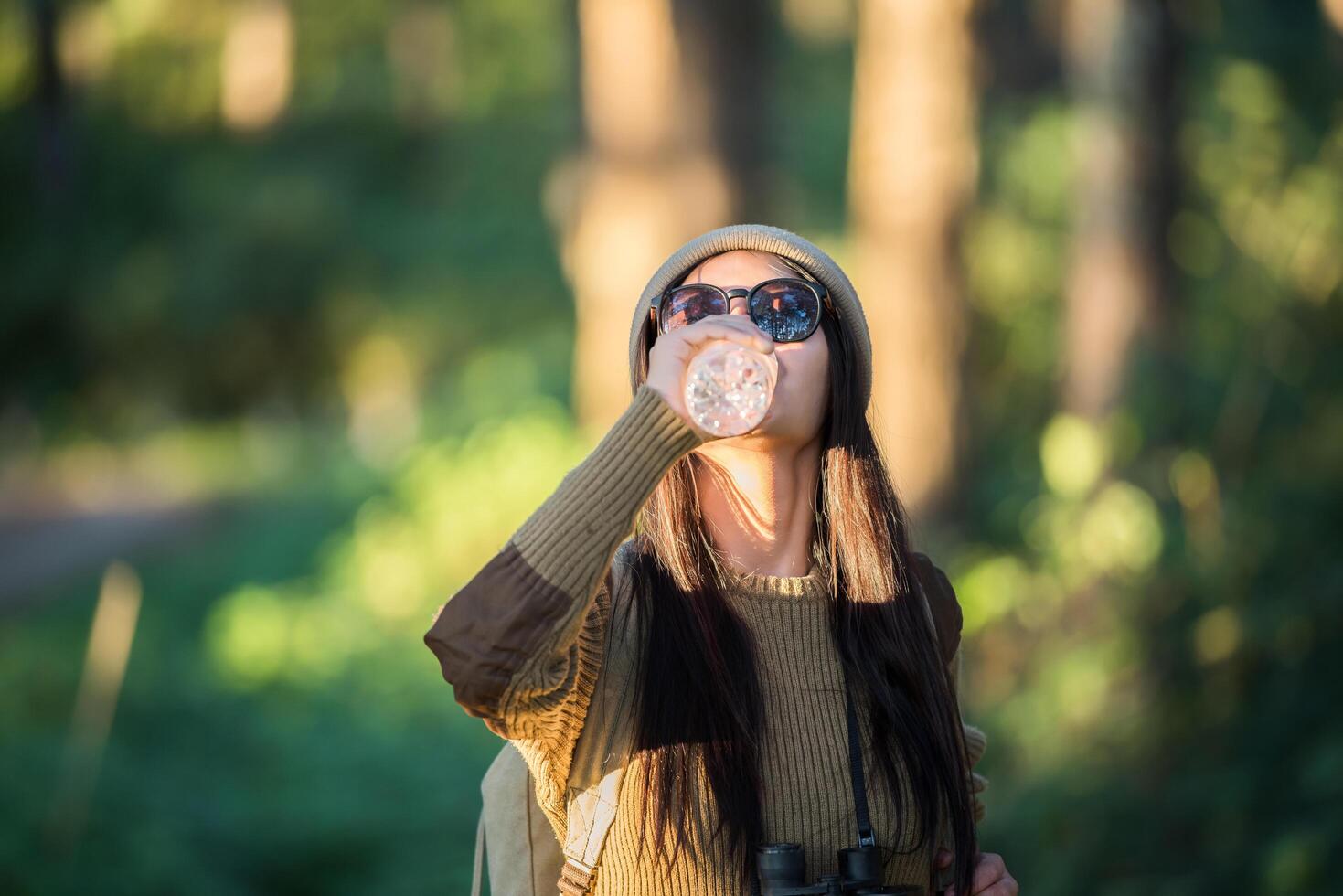 vrouwelijke reiziger die alleen in het bos gaat foto