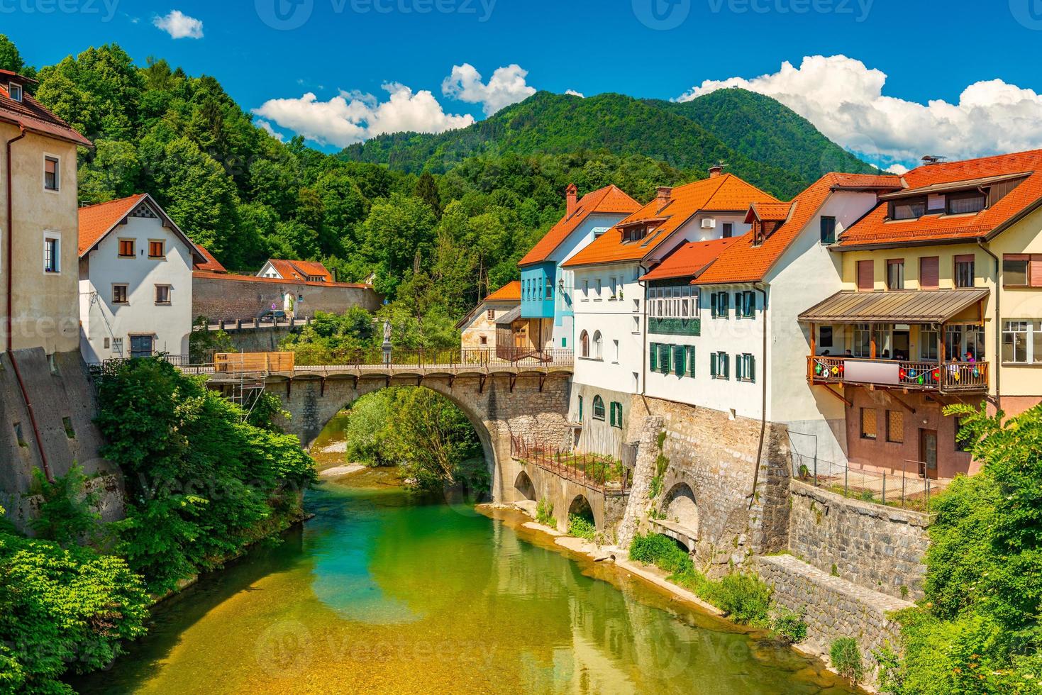 stadsgezicht van skofja loka, slovenië. uitzicht op de kapucijnenbrug over de rivier de selska sora in het oude stadscentrum foto