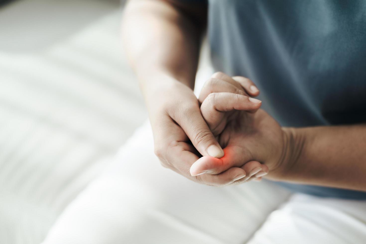 vrouw die lijdt aan hand- en vingergewrichtspijn. foto