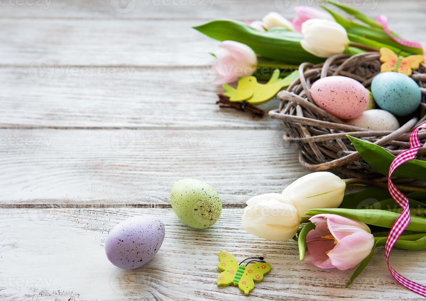 nest met paaseieren en tulpenboeket foto