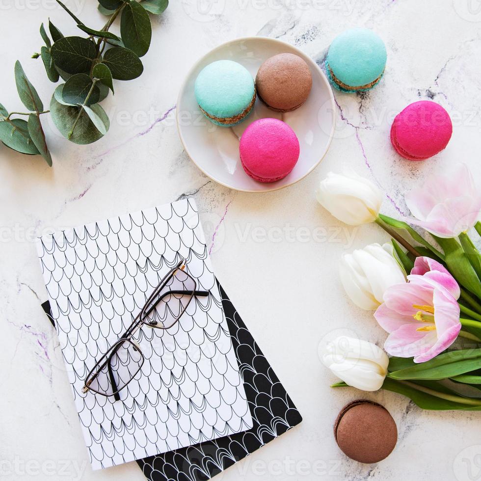 bovenaanzicht van een notebook, bitterkoekjes en tulpen foto