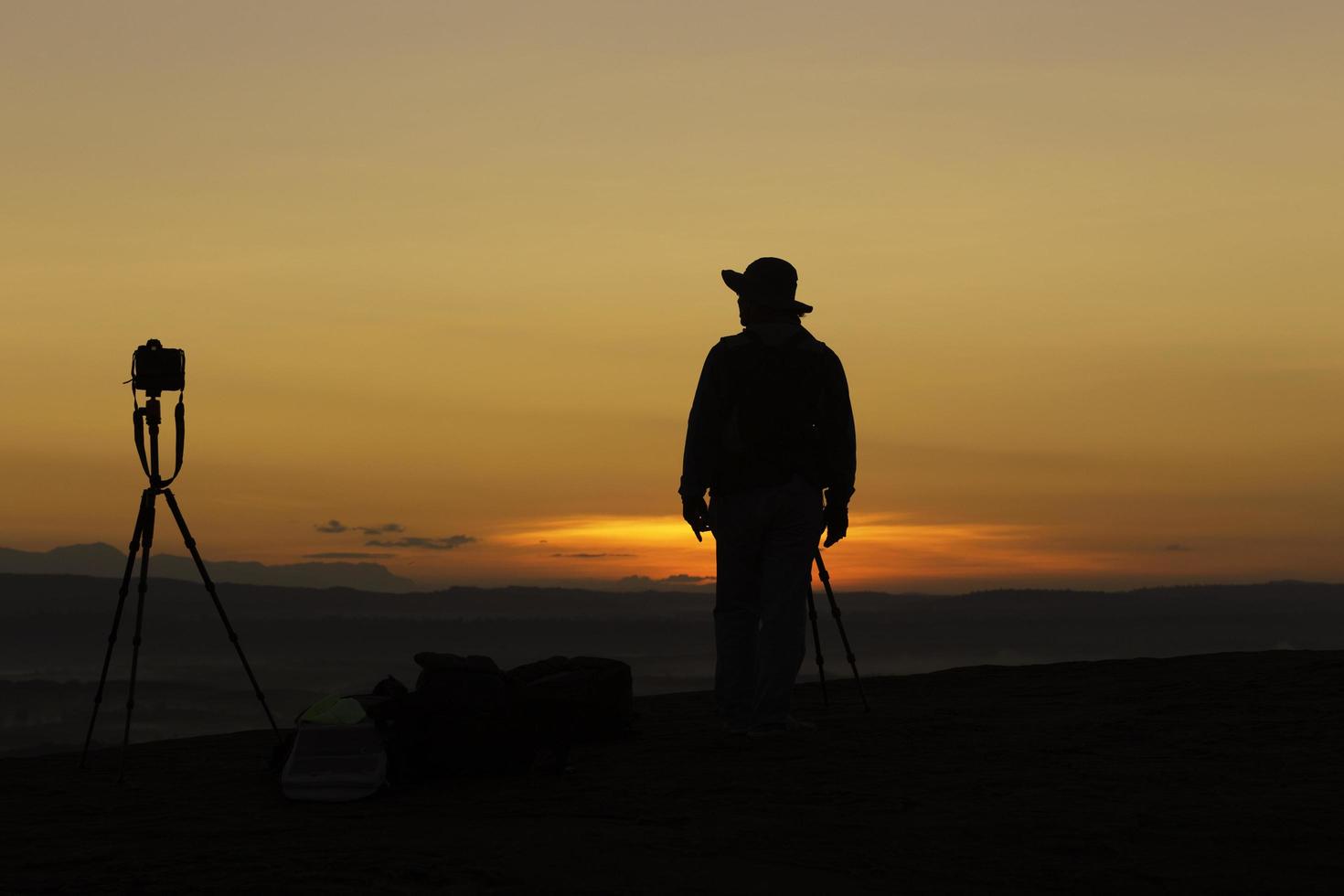 silhouet fotograaf staat alleen en camera schiet in tijdens zonsopgang in bueng kan hin sam wan thailand. foto