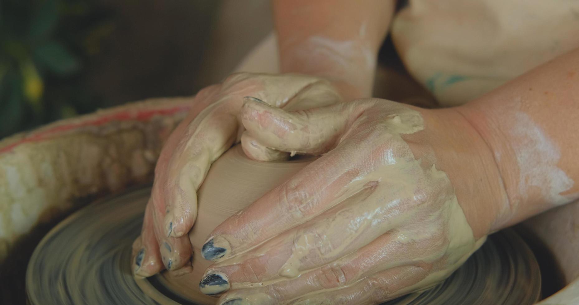 close-up van het handwerk van de vrouw met klei in aardewerkstudio foto