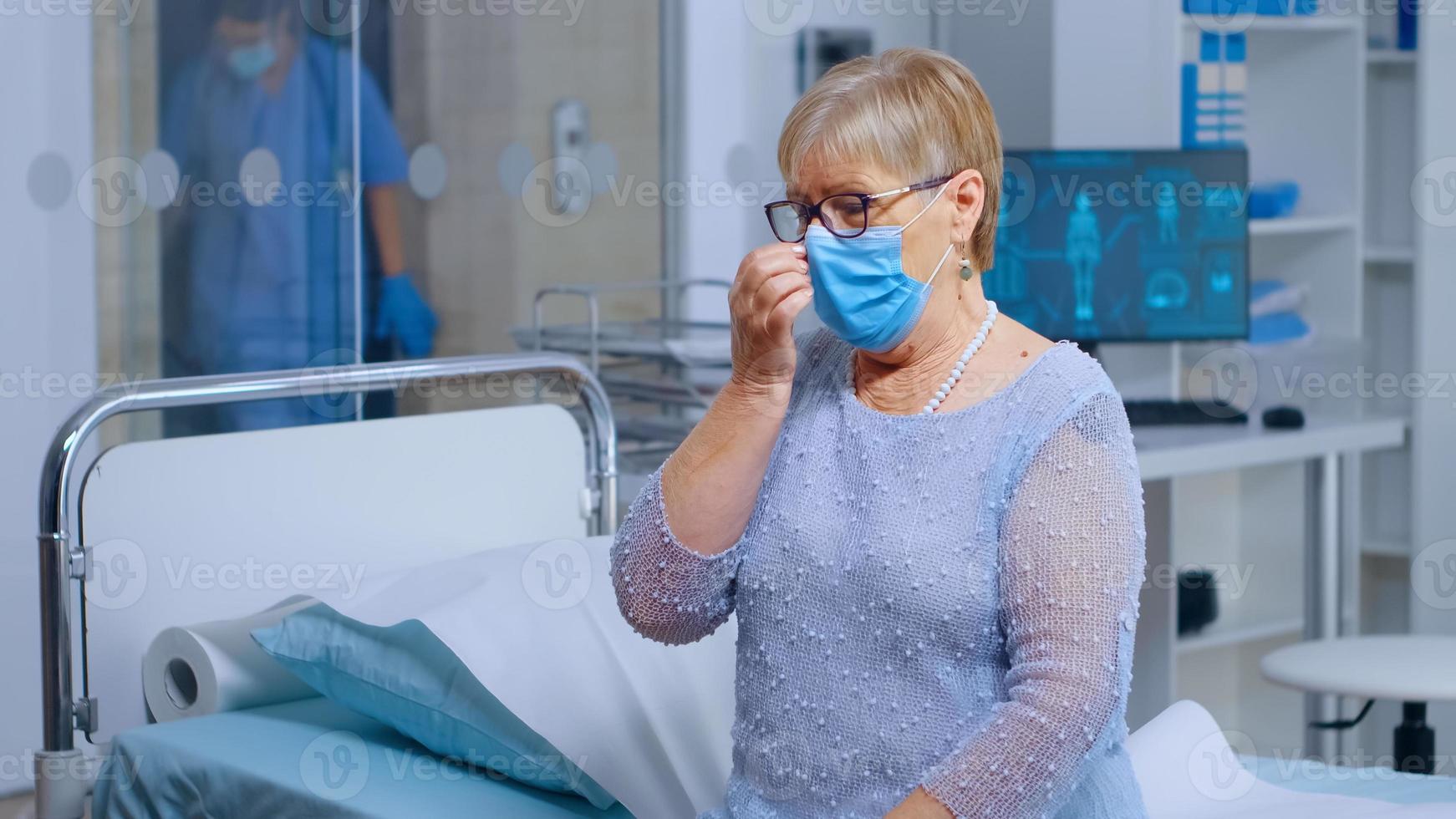 gepensioneerde oude vrouw die een masker draagt bij de dokter foto