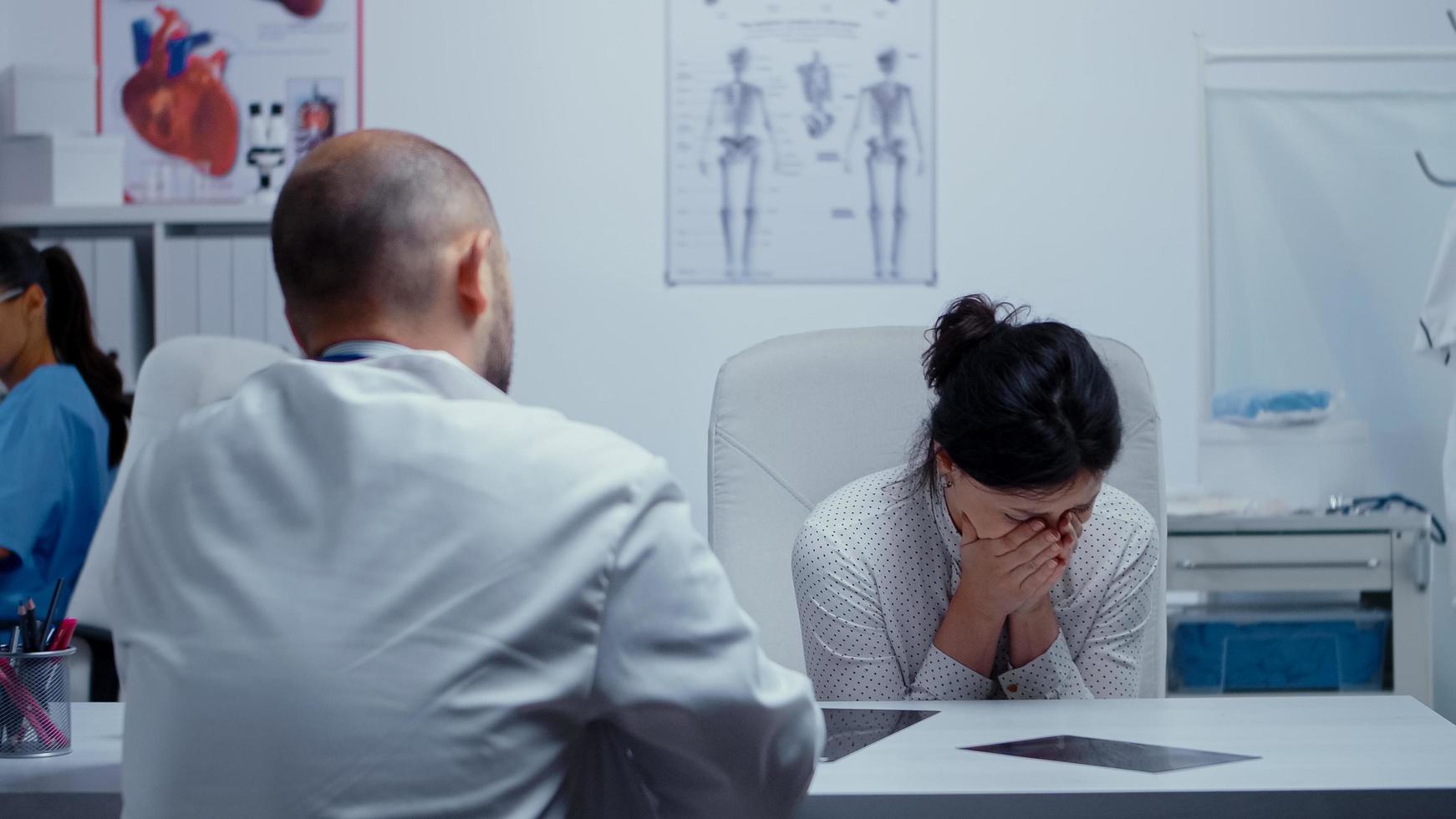 vrouw huilt naar dokter na slecht nieuws foto