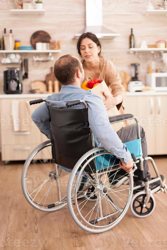 gehandicapte man in rolstoel met boodschappen foto