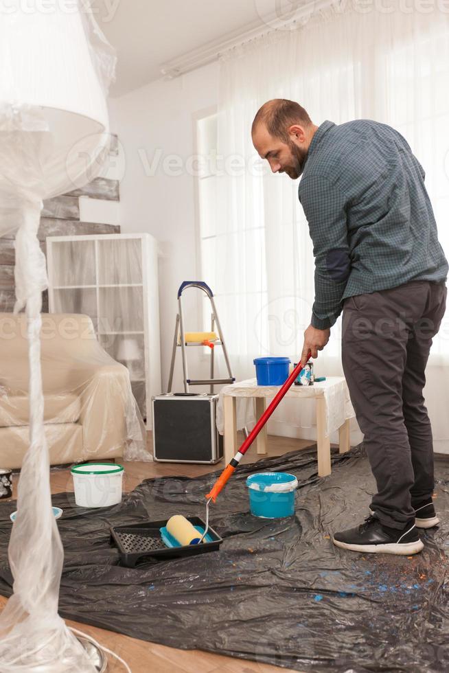 de roller in blauwe verf dompelen foto