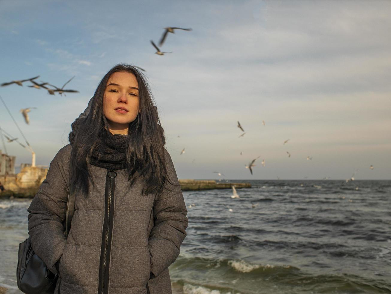 jong meisje staat aan de kust foto