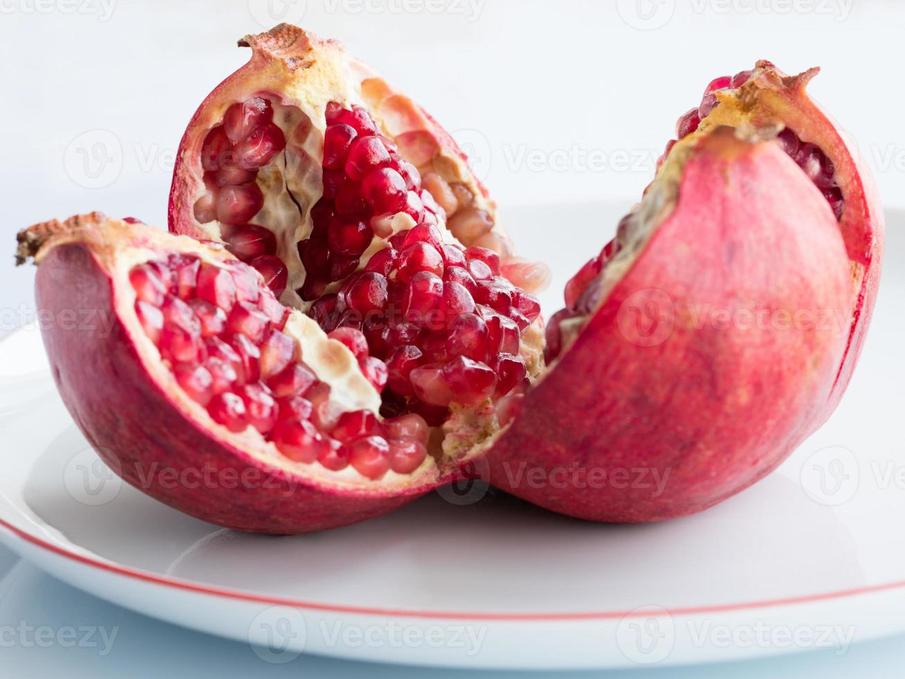 rijp granaatappelfruit op een wit porseleinen bord foto