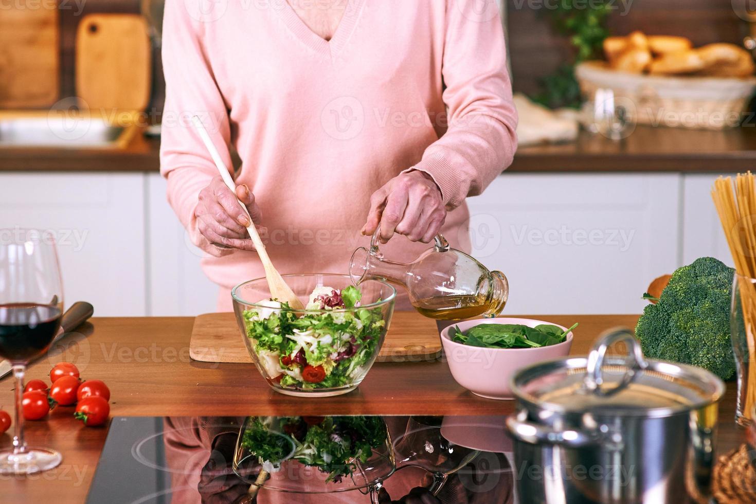 senior vrolijke vrouw kookt in de moderne keuken. voedsel, vaardigheden, levensstijlconcept foto