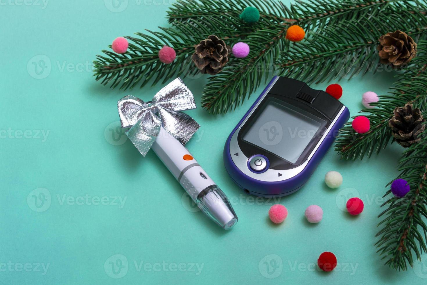 kerstbanner met kerstversiering en een glucometer voor het meten van de bloedsuikerspiegel op een gekleurde achtergrond. kerstkaartconcept voor artsen met kopieerruimte. detailopname. foto