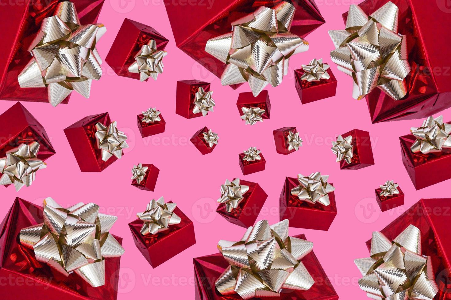 tweede kerstdag. kerst compositie. rood cadeau met een gouden strik op een roze achtergrond. patroon. foto