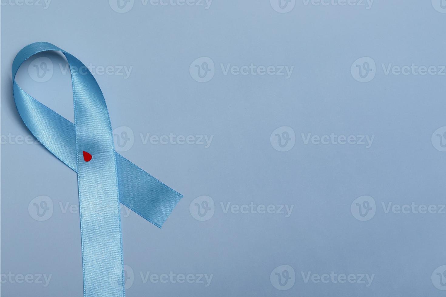 close-up bovenaanzicht van concept voor werelddiabetesdag 14 november. blauw lint met druppels bloed op een blauwe achtergrond foto