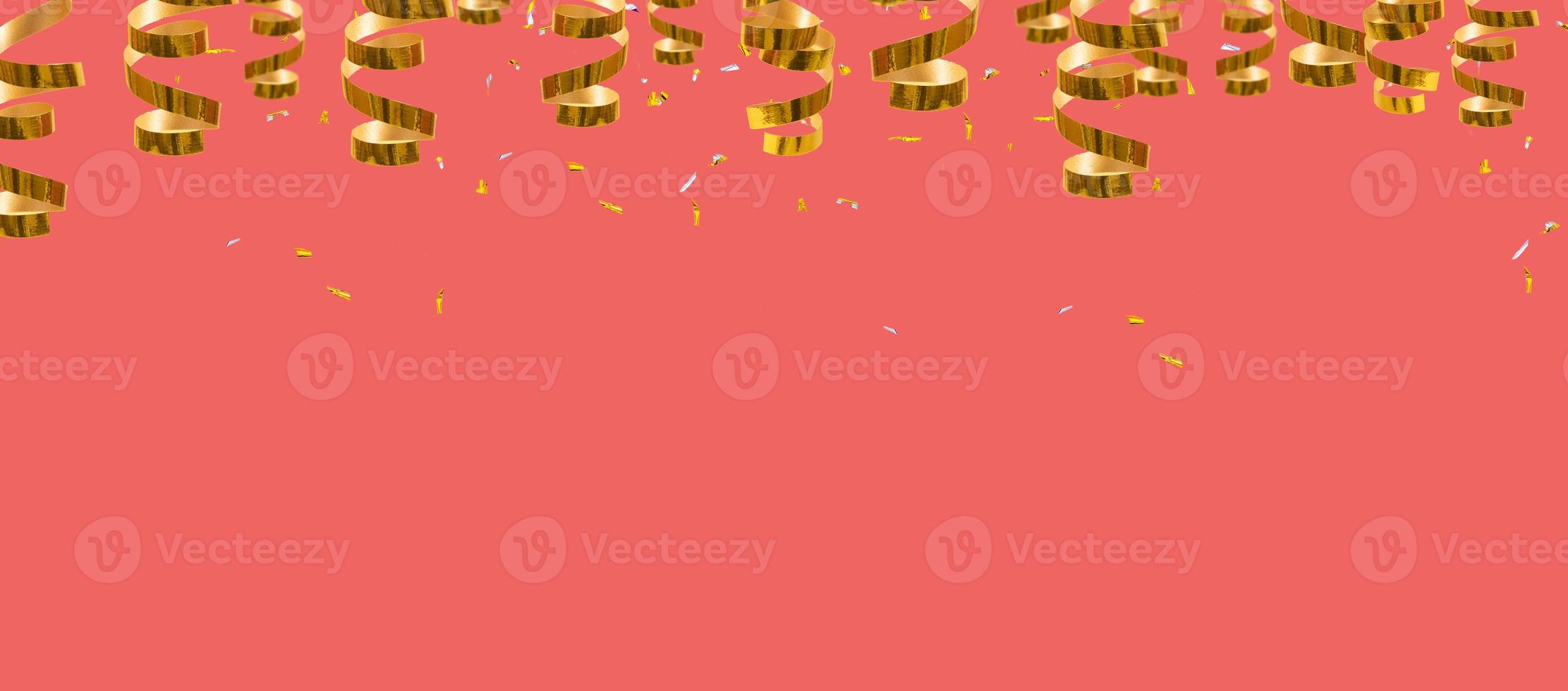 gouden glanzende spiralen, slingers en confetti op een koraalachtergrond met plaats voor tekstbannerachtergrond foto