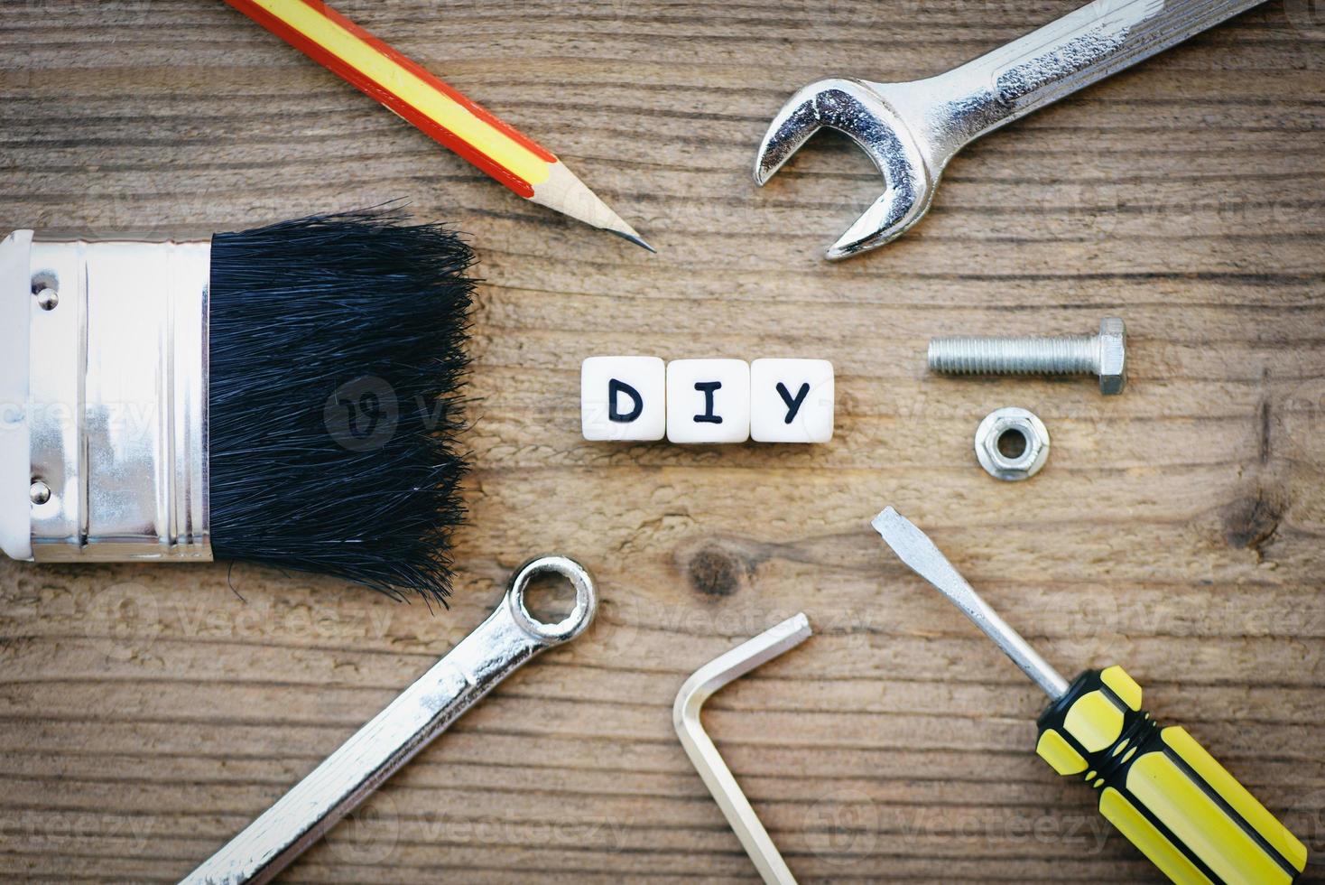 diy tools concept - werkgereedschap met moersleutel schroevendraaier moeren en bouten kwast en diy blog op houten foto