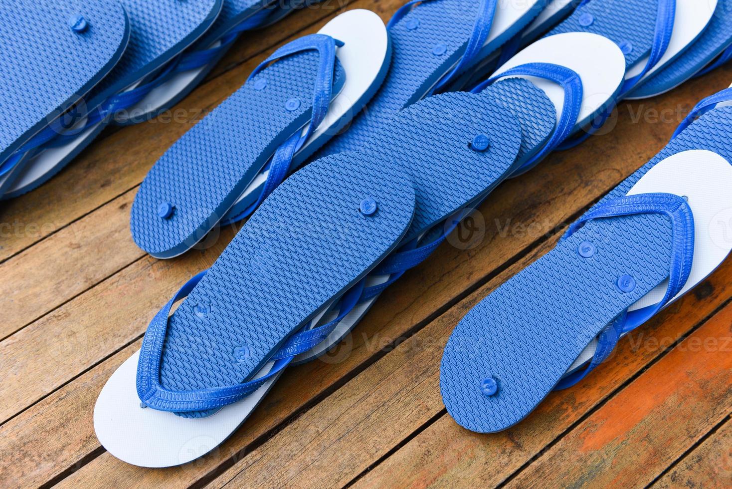 blauwe en witte teenslipper op houten ondergrond - pantoffels teenslippers foto
