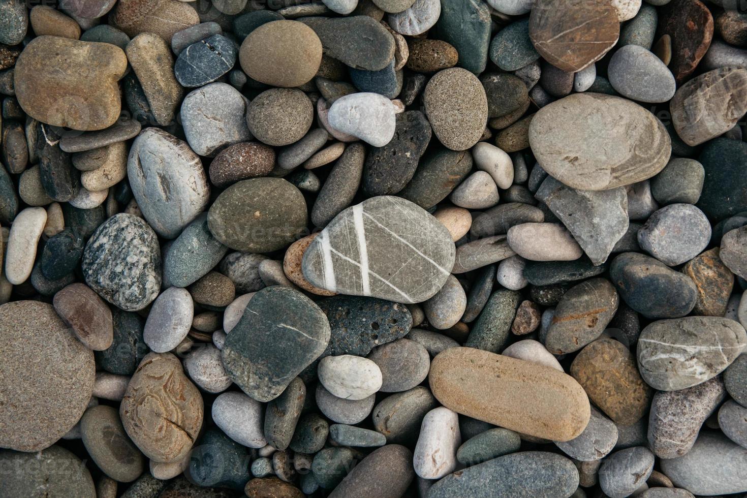 grindpatroon van gekleurde stenen. abstracte natuur kiezelstenen achtergrond. stenen achtergrond. zee kiezels strand. bovenaanzicht. foto