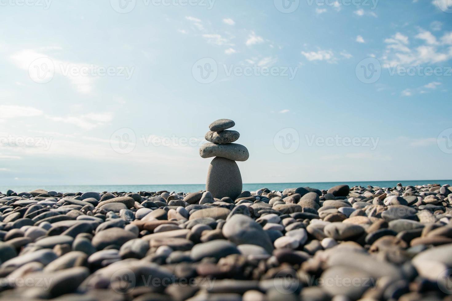 stenen piramide op kiezelstrand symboliseert stabiliteit, zen, harmonie, balans. concept van vrijheid ontspanning. plaats voor tekst of reclame foto