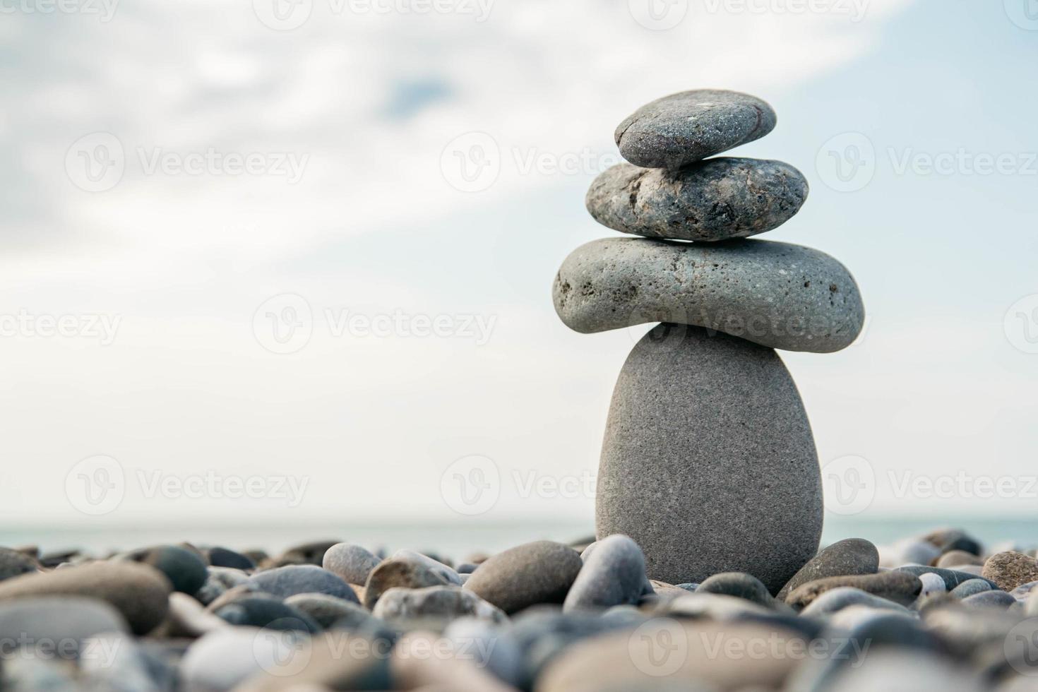 stenen piramide op kiezelstrand symboliseert stabiliteit, zen, harmonie, balans. concept van vrijheid ontspanning foto