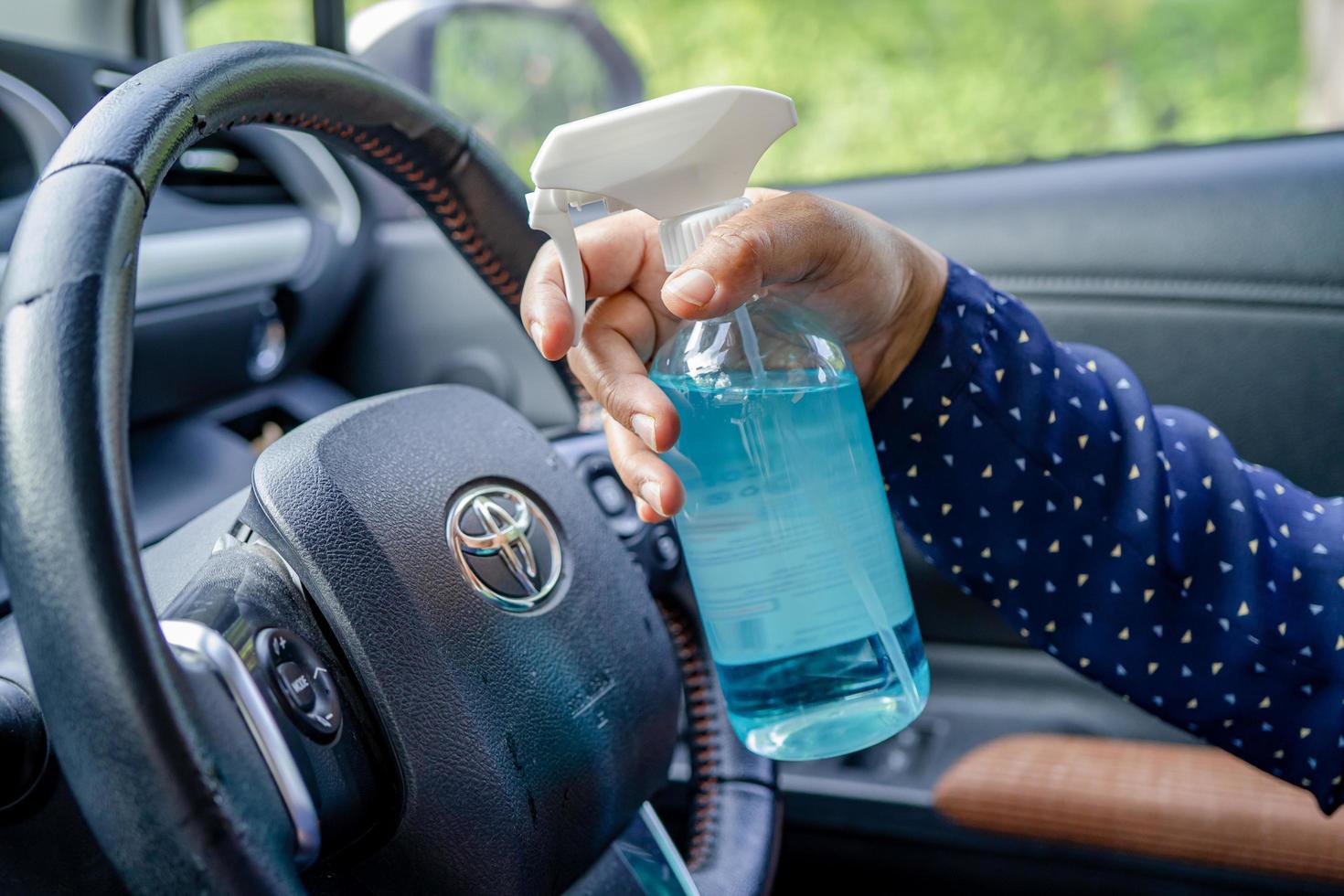 bangkok, thailand, 1 juli 2021 nieuwe normale, aziatische werkende vrouw die de hand wast door op blauwe alcoholdesinfecterende gel te drukken om de veiligheid van het coronavirus in de auto te beschermen. foto