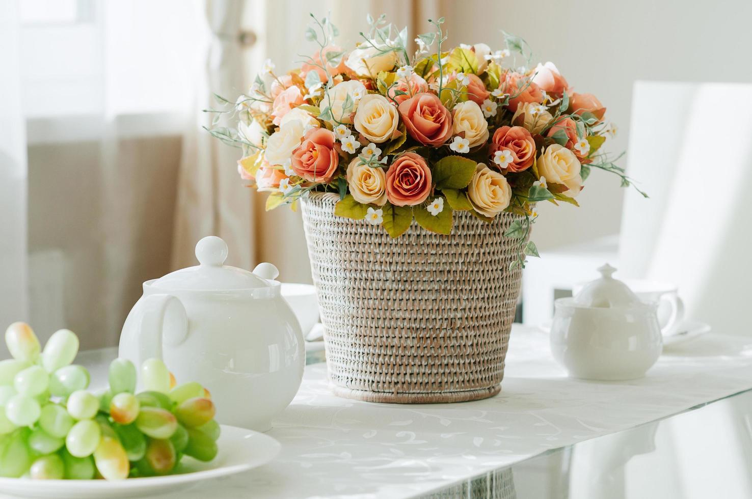 eettafel opgezet met servies voor thee, druiven, bloemen foto