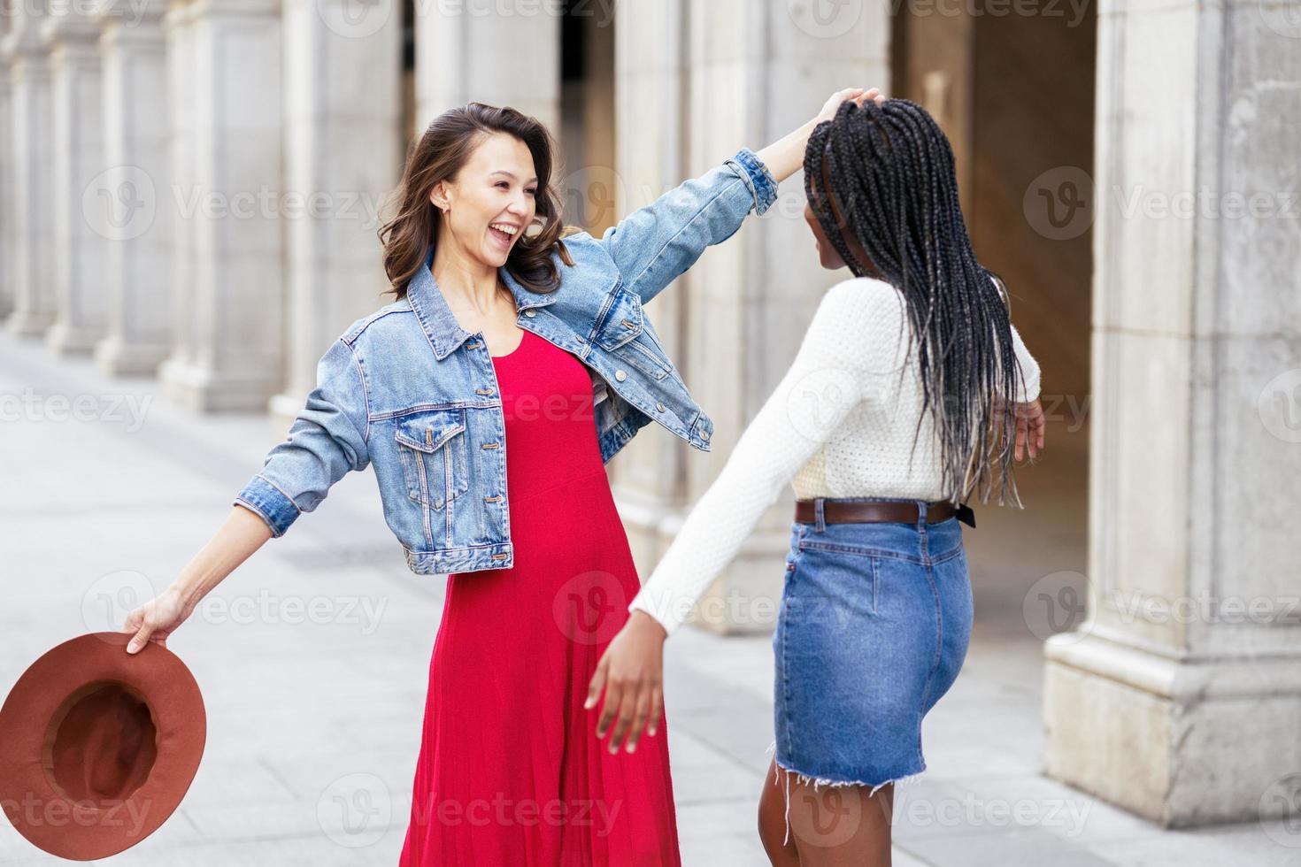 twee vrienden blij elkaar op straat te zien knuffelen. foto