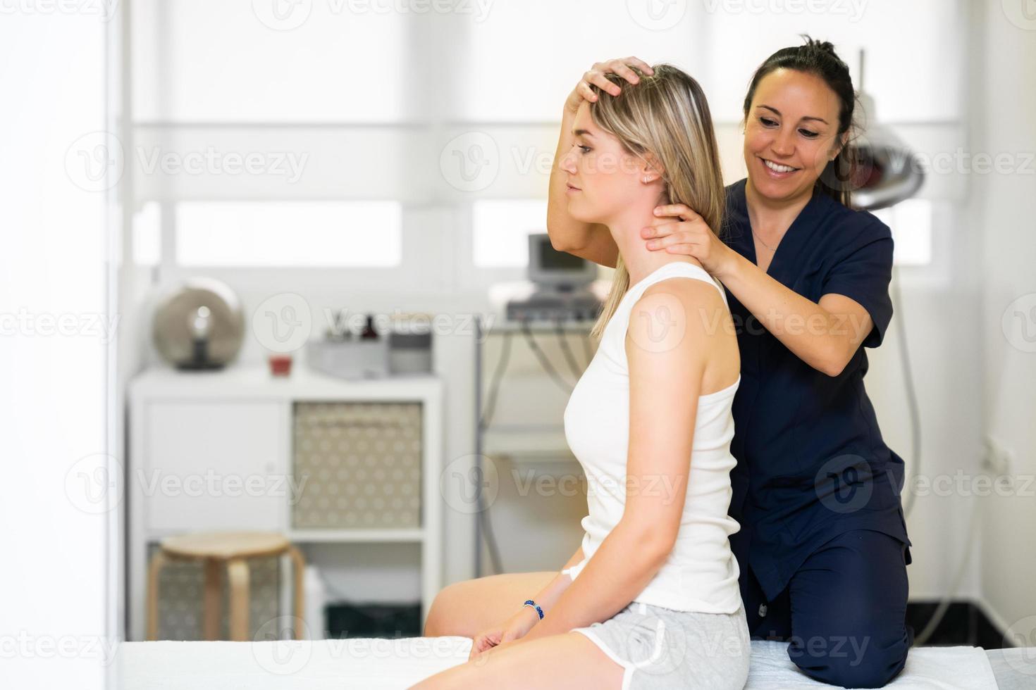 fysiotherapeut die haar patiënt inspecteert in een fysiotherapiecentrum. foto