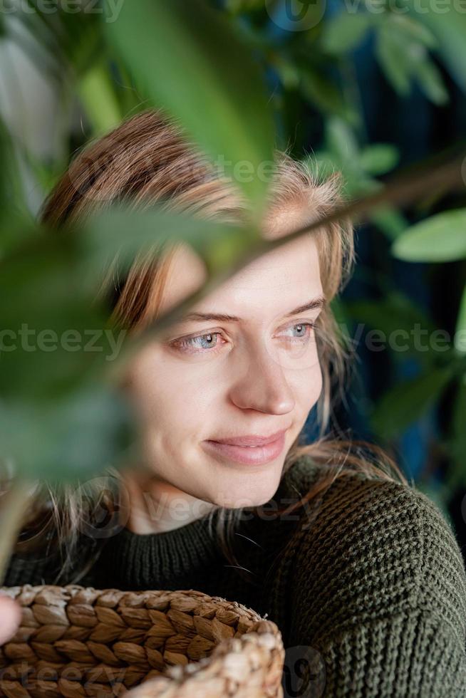 jonge vrouw die thuis voor de planten zorgt foto