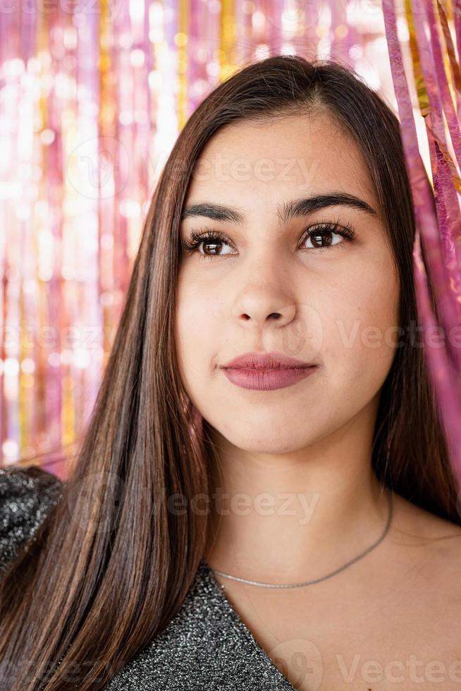 close-up van een vrouw in een glitterjurk die op een glitterpaarse en gouden achtergrond staat foto