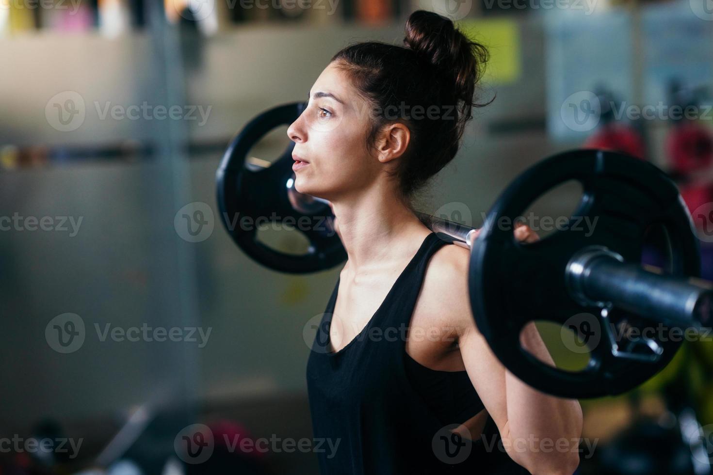 atletische vrouw in sportschool gewichtheffen in de sportschool foto