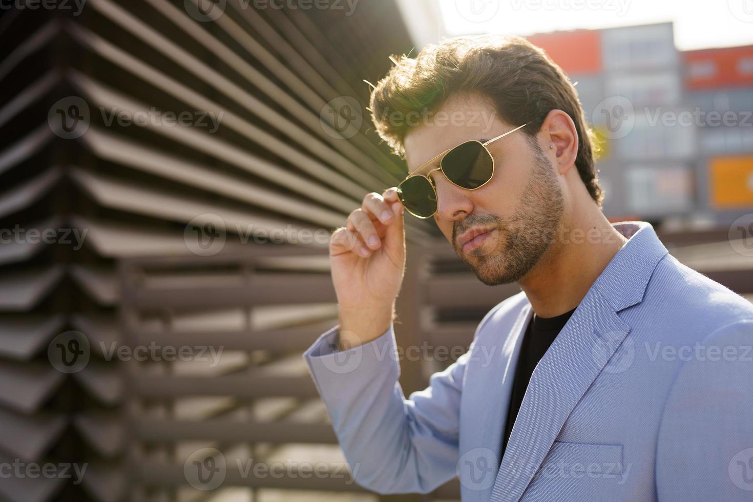 jonge knappe man met zonnebril op stedelijke achtergrond foto