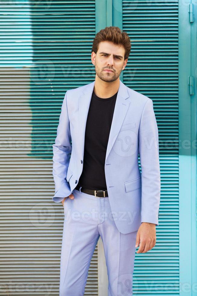 aantrekkelijke man met een pak dat op een stedelijke achtergrond staat. foto