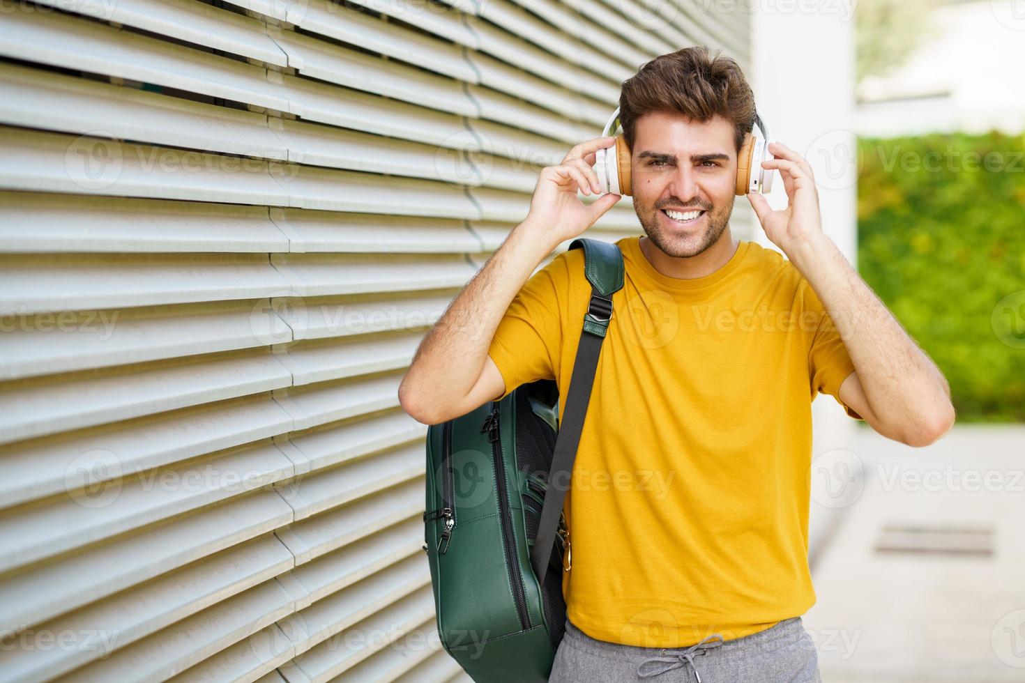 jonge man met koptelefoon op stedelijke achtergrond foto