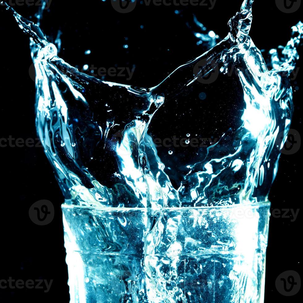 lichtblauw transparant watergolfoppervlak met plonsbel op glaswaterzwart. foto