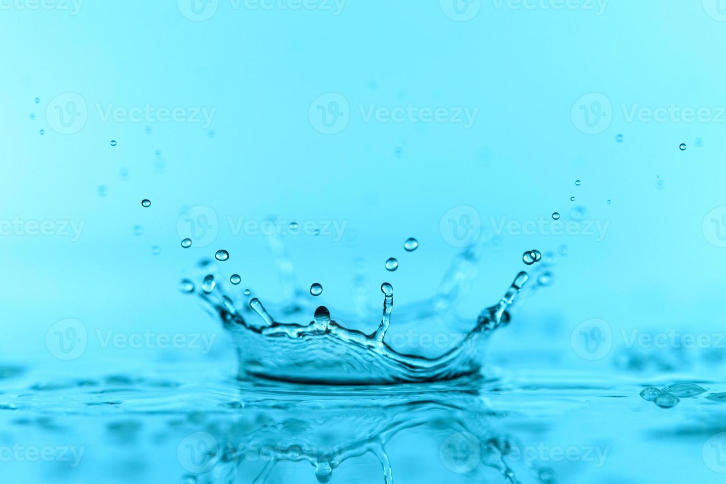 lichtblauw transparant watergolfoppervlak met plonsbel op blauw. foto