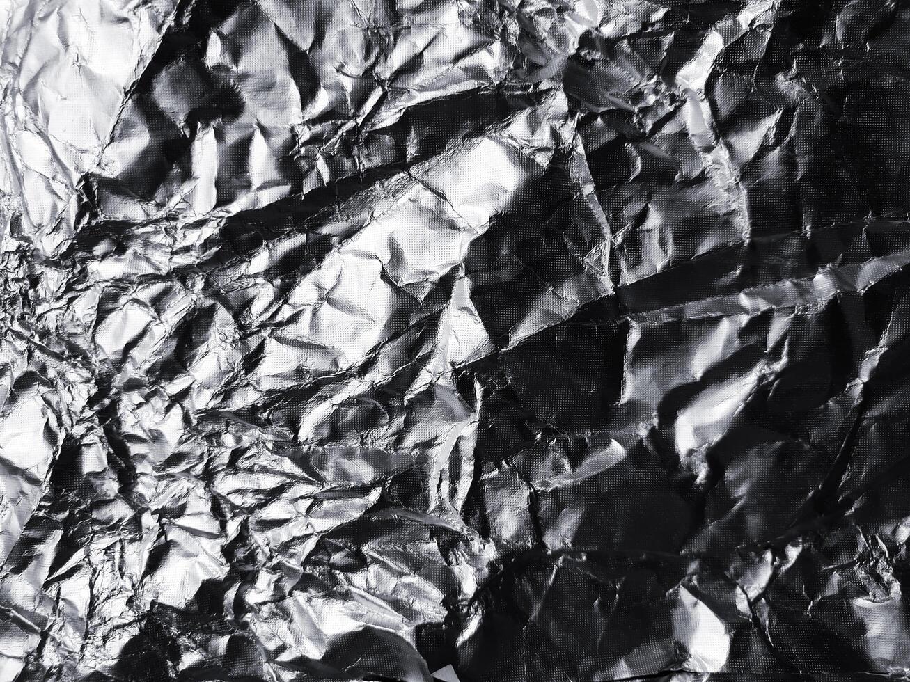 het oppervlak van aluminiumfolietextuur voor achtergrond- en ontwerpmaterialen. verfrommelde textuurcollectie van zilverfolie. abstracte gerimpelde patroonachtergrond foto