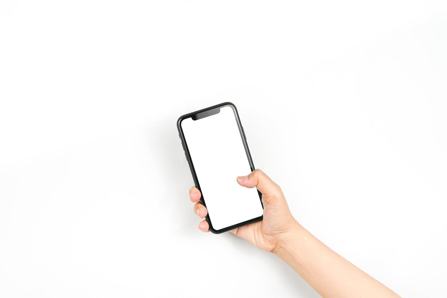 een smartphone vasthoudend met twee handen alsof hij een chat typt. een smartphone met een leeg wit scherm dat wordt gebruikt voor reclamemockup. foto