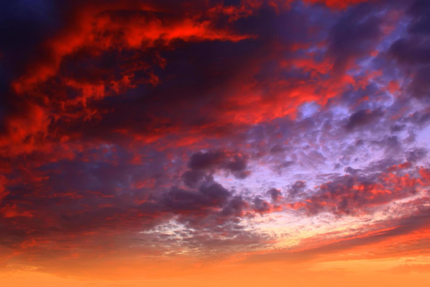 schitterende oranje zonsondergang en zonsopgang mooi boven witte en grijze wolken met fel oranje en rode zon op een koele lenteochtend. foto