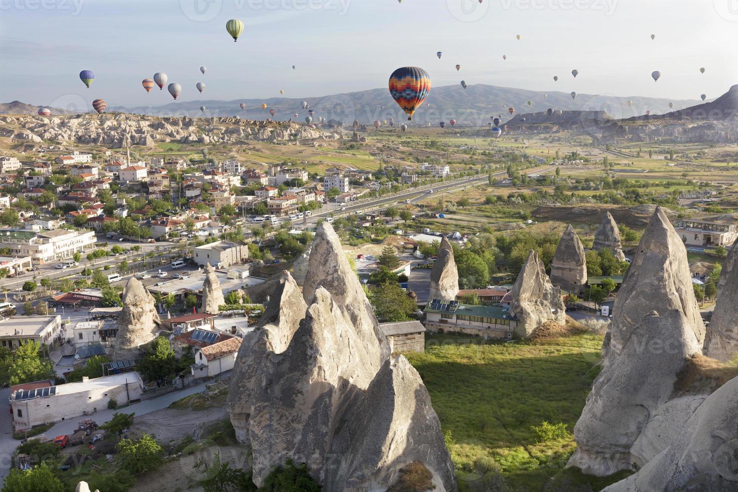 tientallen ballonnen vliegen over de valleien in Cappadocië foto