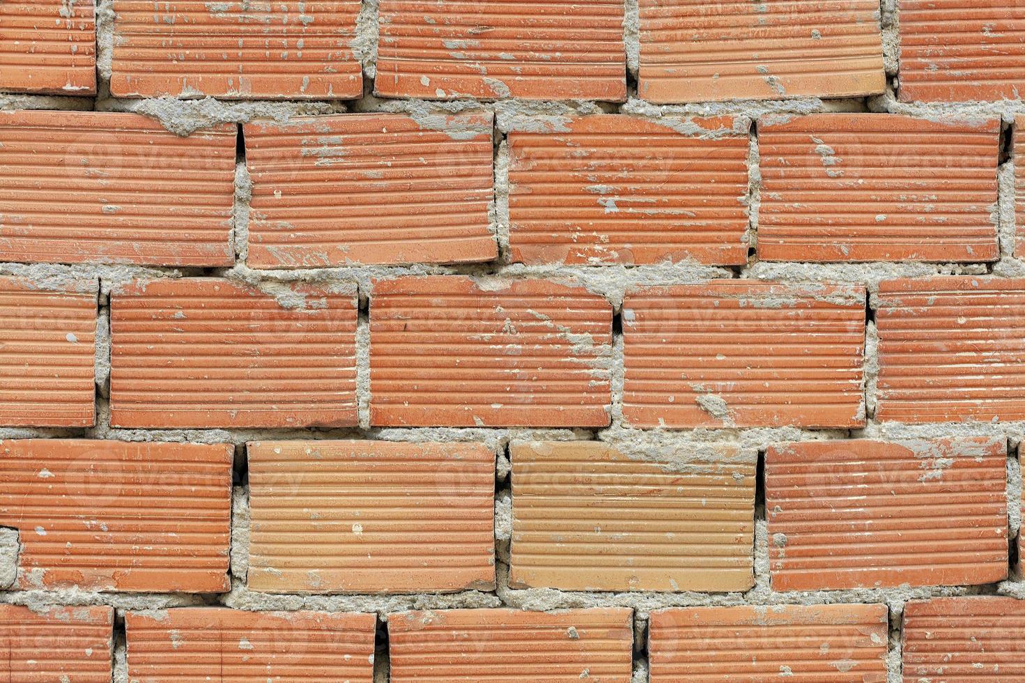 de uitgesproken textuur van corpulente baksteen op de muur met een cementnaad. foto