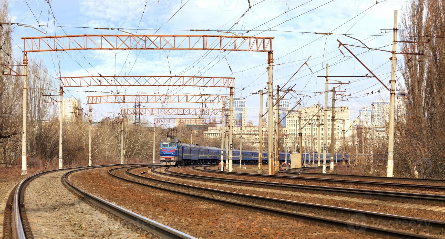 passagierstrein auto's van de trein rijden op de spoorlijnen op de achtergrond van het stadsbeeld foto