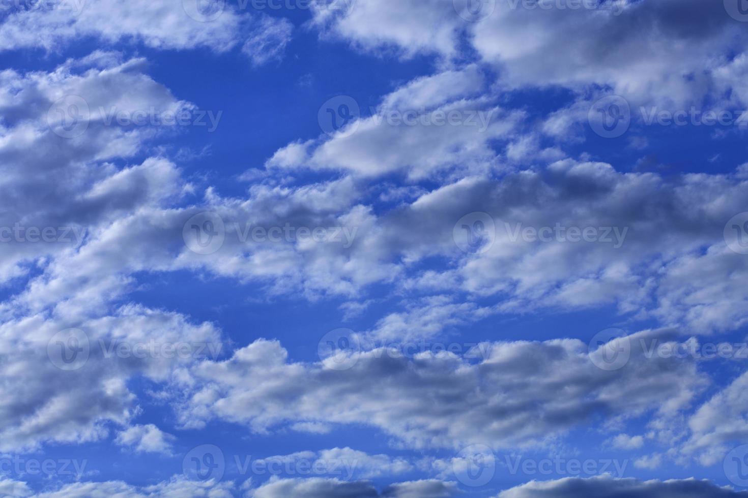 witte wolken zweven in een heldere, verzadigde blauwe lucht foto