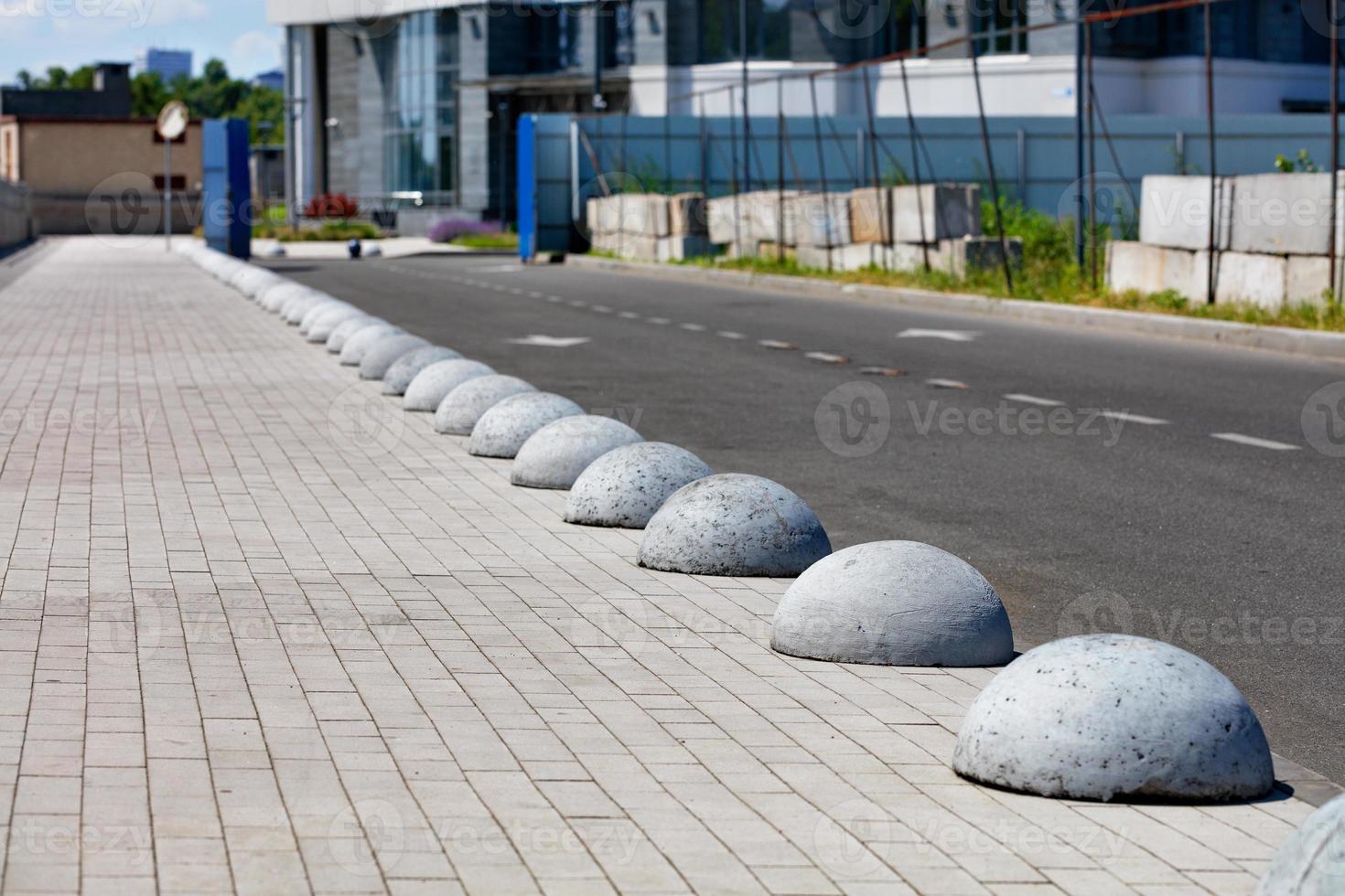 de rijbaan en het voetpad worden gescheiden door betonnen halve bollen die zich diagonaal in de verte uitstrekken. foto