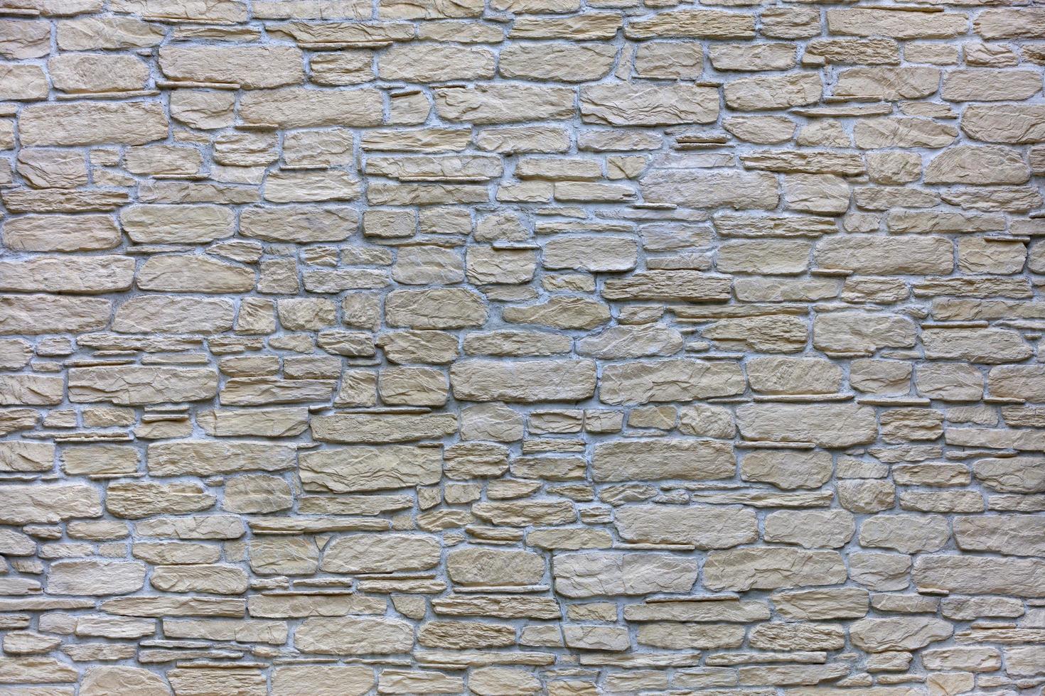 textuur van een beige stenen muur van een grote geplaveide stenen close-up foto