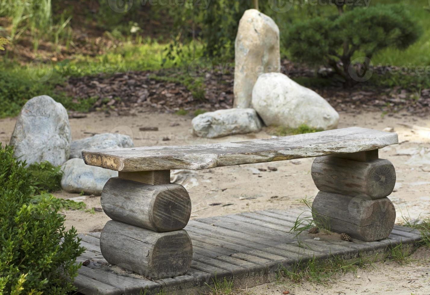 houten bank in de Japanse tuin van stenen foto