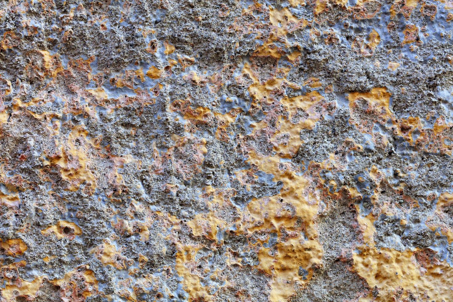de textuur van de muur is bedekt met grijsblauw stucwerk afgewisseld met goudfragmenten. foto
