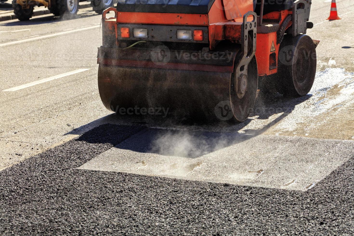 een zware vibrerende wals verdicht asfalt op de te repareren weg. foto