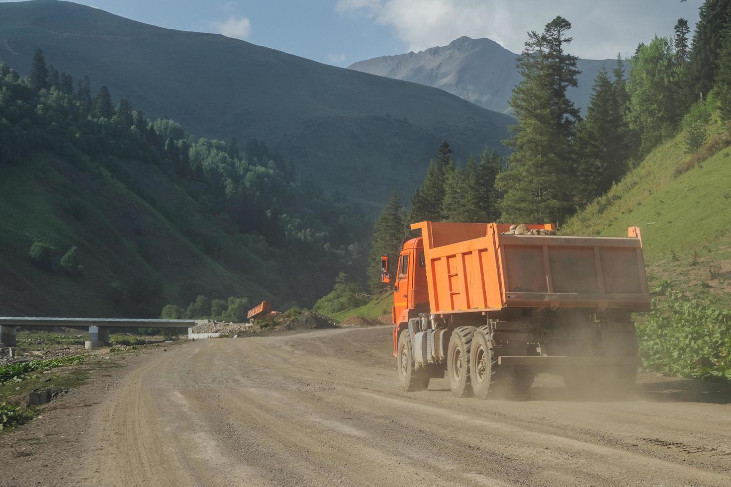 geladen dumper rijden op een onverharde weg in de bergen. foto