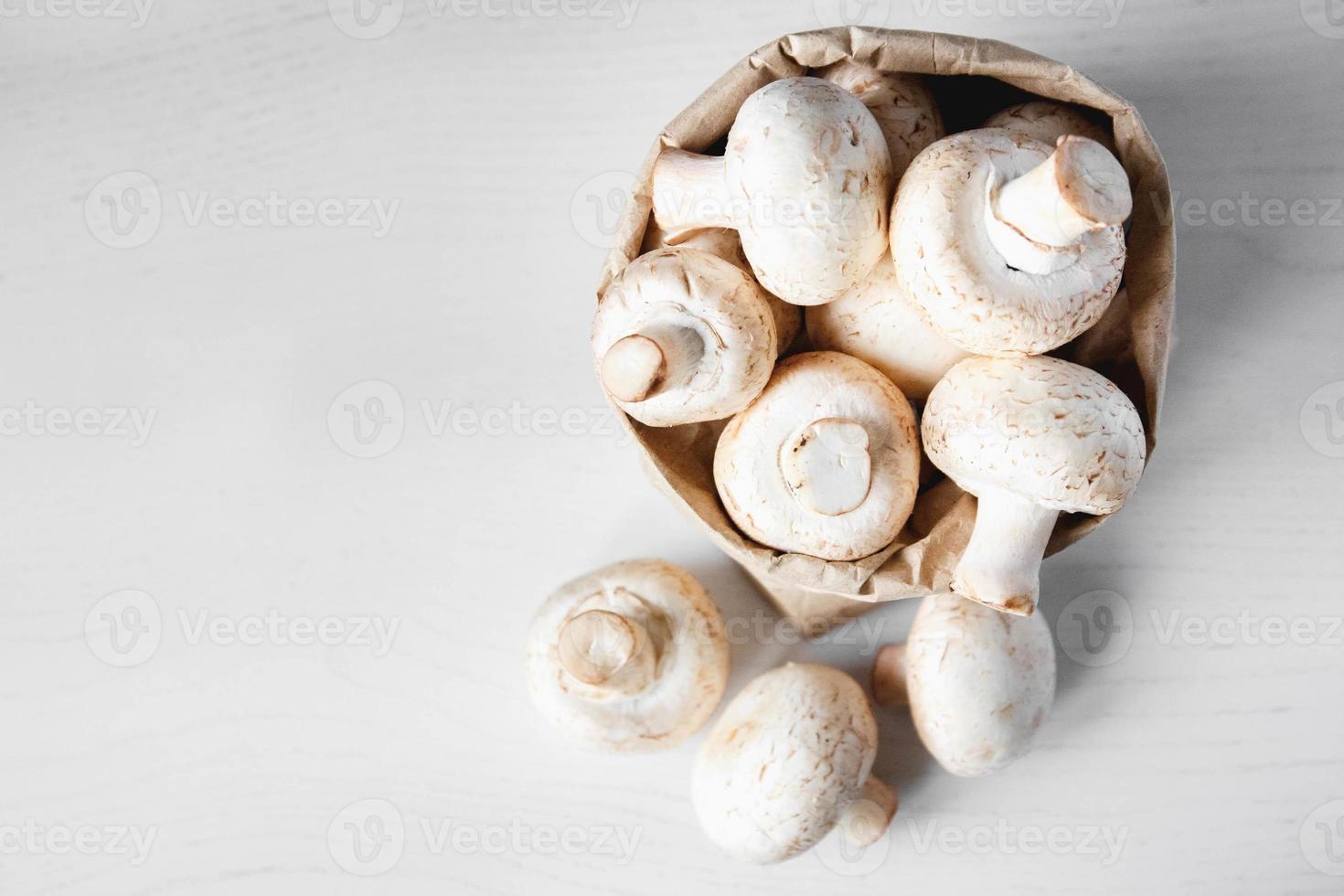 champignons champignons in papieren zak op een witte houten tafel foto